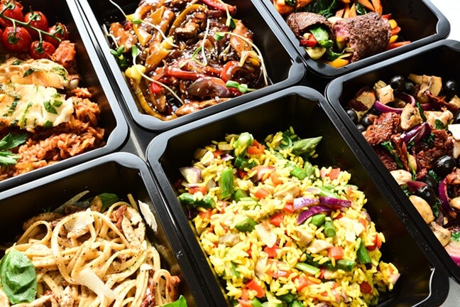 Zestaw zbilansowanych posiłków w pudełkach, ułatwiający regularne odżywianie w pracy i w domu.